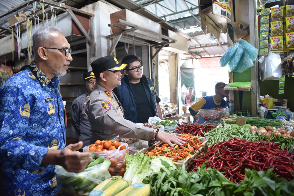 Kapolres Gresik AKBP Ramadhan Nasution didampingi Kadiskoperindag Darmawan saat meninjau lapak penjual sayuran di Pasar Baru Gresik. SP/Maidid