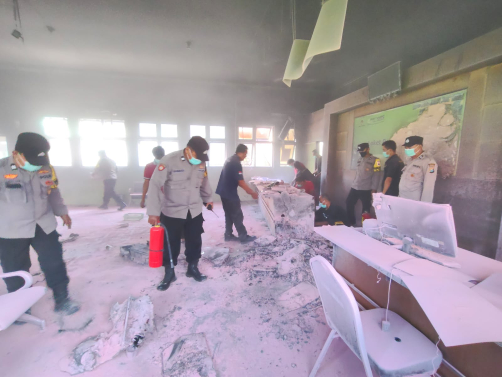 Petugas kepolisian bersama petugas rumah sakit memeriksa lokasi kebakaran di ruang loket pendaftaran poli rawat jalan RSUD Caruban, Kabupaten Madiun, Sabtu (7/3/2026).