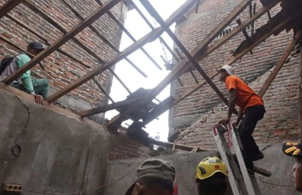 Sejumlah petugas BPBD Kota Madiun dan gabungan relawan melakukan gotong royong evakuasi material atau atap rumah warga di Kelurahan Manguharjo Kota Madiun. SP/ MDN