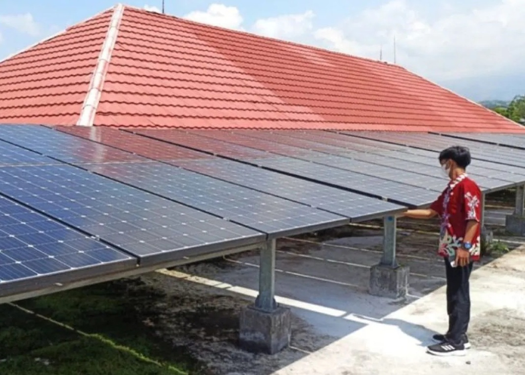 Petugas melakukan pembersihan panel pada pembangkit listrik tenaga surya (PLTS) atap yang dikembangkan di kantor Dinas Peternakan dan Perikanan (Disnakkan) Kabupaten Magetan. SP/ MGT