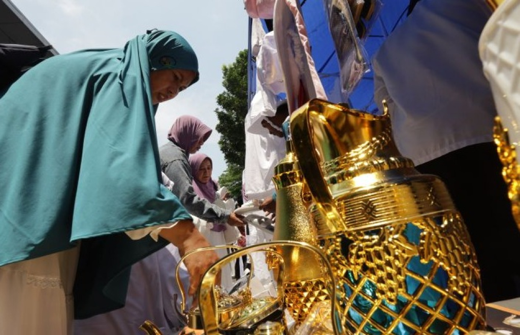 Jamaah calon haji memilih pernak-pernik haji yang dijual pedagang saat upacara pelepasan jamaah calon haji di Kabupaten Kediri, Jawa Timur. SP/ KDR