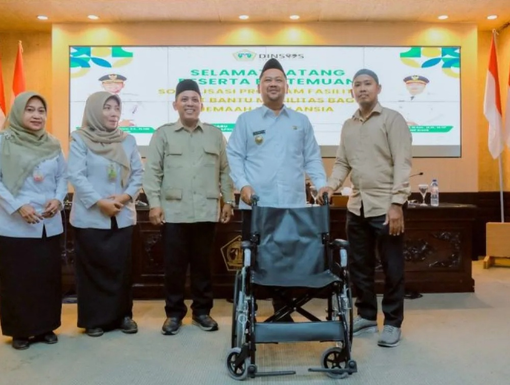 Bupati Gresik Fandi Akhmad Yani (tengah) menunjukkan kursi roda bantuan saat sosialisasi program fasilitasi jamaah calon haji di Kantor Bupati Gresik. SP/ GRS