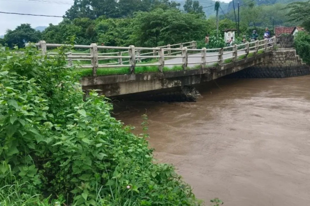 Kondisi Jembatan Junjung di Tulungagung, Jawa Timur, yang patah pada bagian tengah akibat tertimpa material kayu dan enceng gondok saat banjir pada 2024. SP/ TLG