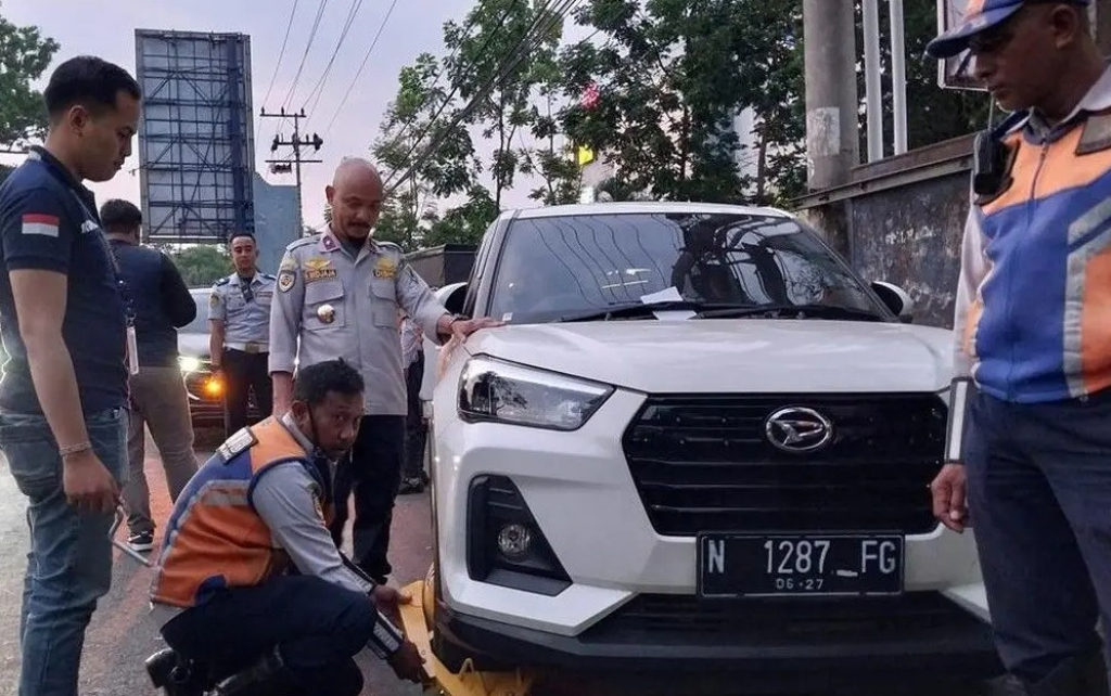 Mobil yang parkir liar di Kota Malang digembok petugas Dishub. Dengan adanya Perda Parkir untuk buka gembok ada denda Rp 500 ribu. 