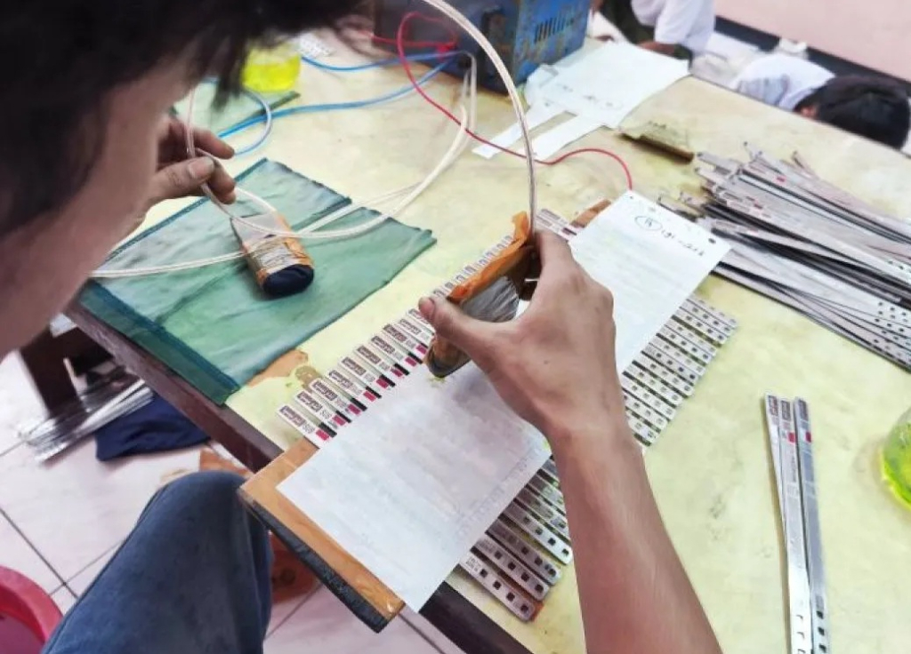 Pekerja menyelesaikan gelang identitas jamaah calon haji di Asrama Haji Embarkasi Surabaya, Jawa Timur. SP/ SBY