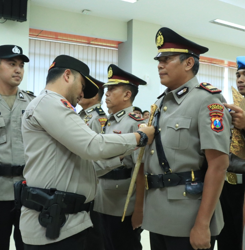 Kapolres AKBP Ramadhan Nasution saat memasang lencana jabatan Kapolsek Kebomas kepada AKP Tatak Sutrisno pada sertijab sejumlah PJU Polres Gresik. SP/ MAIDID