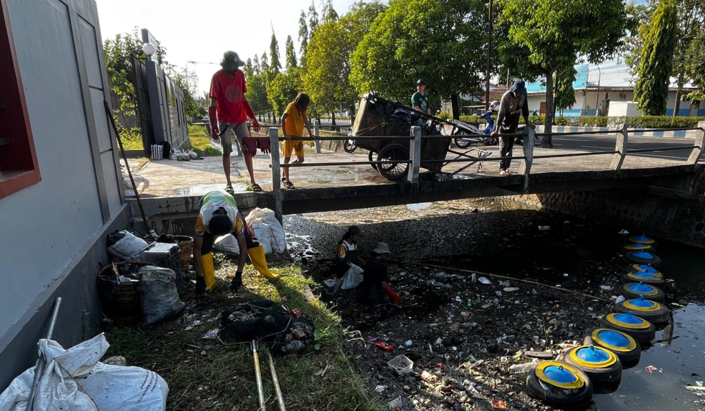 Sejumlah pemuda yang tergabung dalam KPS Tonatan berjibaku membersihkan sampah yang mencemari sungai Tambak Kemangi. 