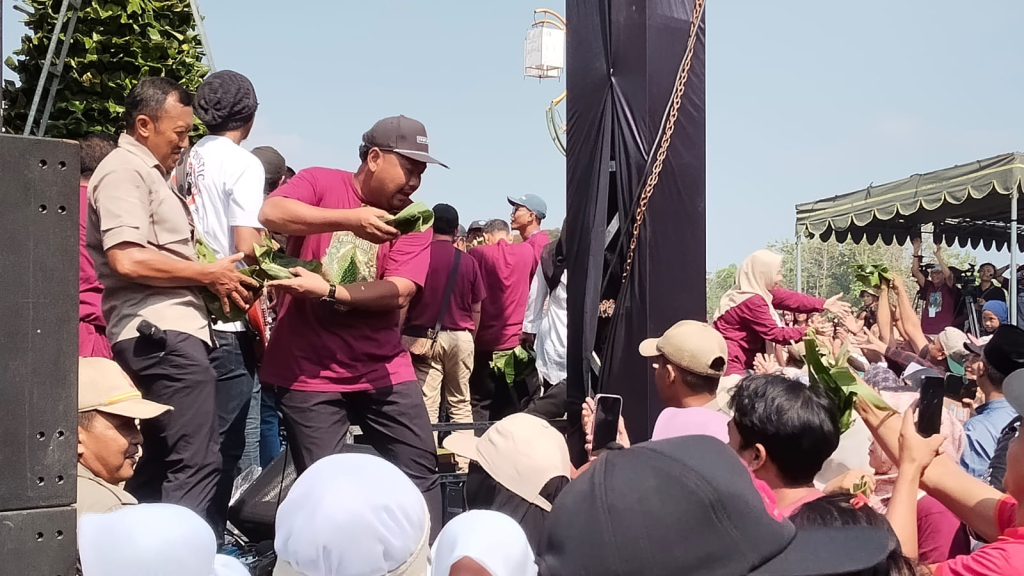 Bupati Gresik Fandi Achmad Yani ikut sibuk membagikan 3.0000 bungkusan nasi krawu kepada pengunjung Festival Tumpeng Nasi Krawu KWGe di arena Gresik Universal Science (GUS) Balongpanggang. SP/ MAIDID