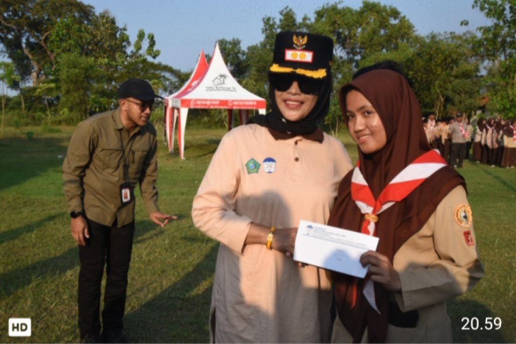 Wakil Bupati Sidoarjo, Hj. Mimik Idayana, saat menyerahkan bantuan kepada siswi peserta kegiatan "1.000 Yatim Camp" di Bumi Perkemahan Tanjek Wagir, Sidoarjo. SP/HIKMAH