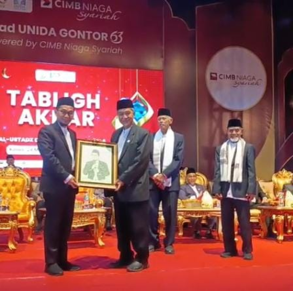 Rektor UNIDA Gontor, Prof. Dr. KH. Hamid Fahmy Zarkasyi saat memberikan kenang-kenangan dari hasil karya mahasiswa kepada Ustaz Adi Hidayat. 