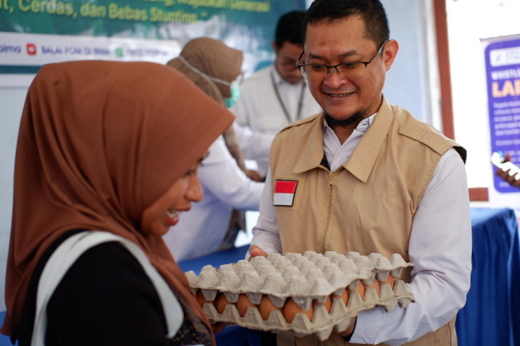 Kepala Balai POM di Bima, Adjis Sanjaya saat menyerahkan bahan pangan kepada warga dalam kegiatan sosialisasi "Cegah Stunting dengan Gizi Seimbang dan Pangan Aman". SP/HIKMAH