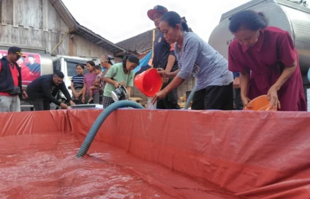 Warga saat mengambil air dari tempat penampungan bantuan air. SP/NGW