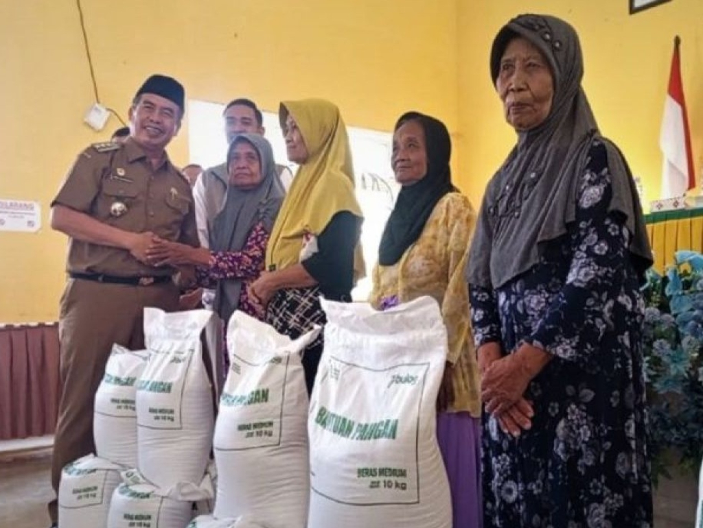 Bupati Madiun Hari Wuryanto bersama Pimpinan Cabang Bulog Madiun Agung Sarianto menyerahkan bantuan pangan beras kepada warga sasaran di Desa Balerejo. SP/MDN