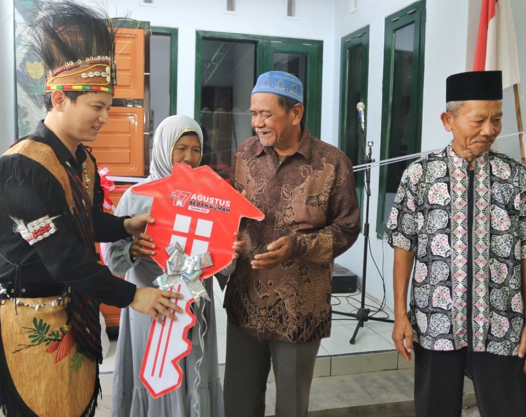 Bupati Trenggalek Mochamad Nur Arifin (kiri) secara simbolis menyerahkan kunci rumah kepada penerima manfaat program bedah rumah di Kelurahan Tamanan. SP/TRG