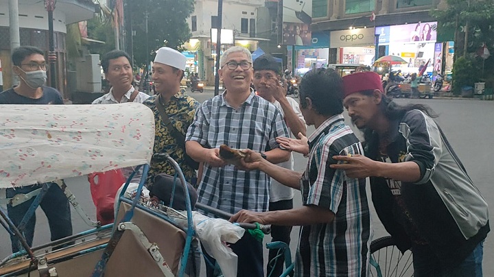 Anggota DPR RI Prof Zainuddin Maliki bersama jurnalis yang bergabung dalam Komunitas Wartawan Gresik membagikan kuliner khas Gresik Nasi Krawu kepada abang becak di kawasan Bandar Grissee, Rabu (21/12). SP/Grs