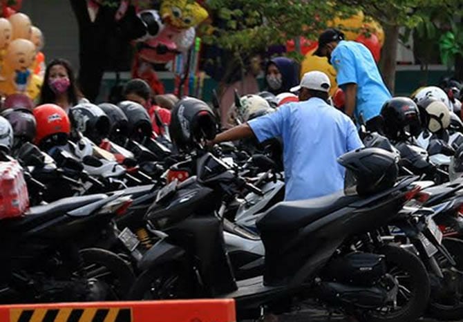 Juru parkir menjaga kendaraan di kawasan perbelanjaan Pasuruan. Pemkot Pasuruan tengah mewacanakan memakai e-parking