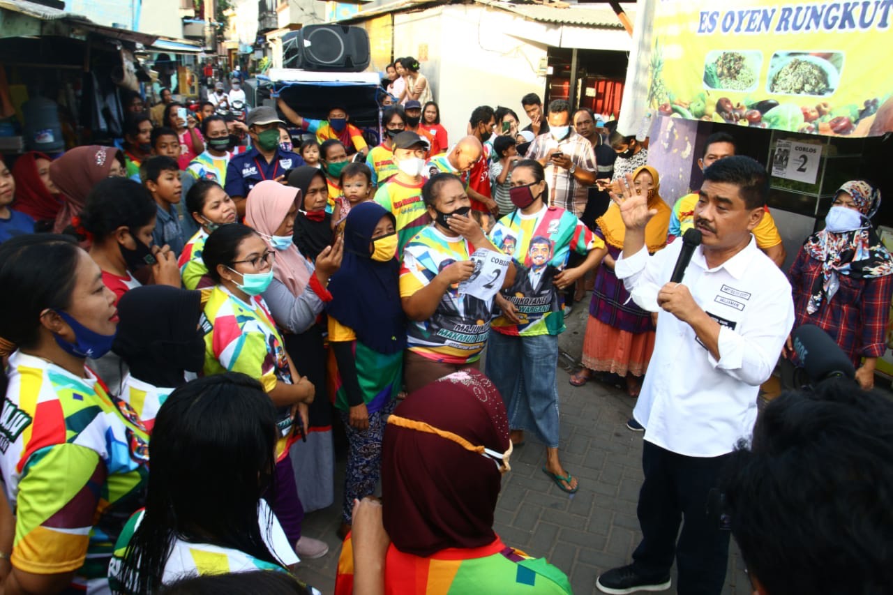 Calon Wakil Wali Kota Surabaya nomor urut 2 Mujiaman menyusuri gang kecil di Kelurahan Rungkut Tengah, Kamis (12/11) petang .SP/ALQOMARUDDIN