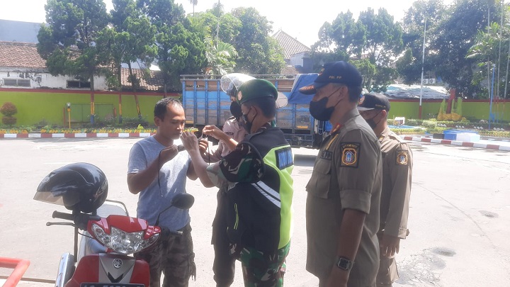 Tim Gabungan Pamor Keris Polres Blitar Kota membagikan masker kepada masyarakat saat patroli. SP/Her