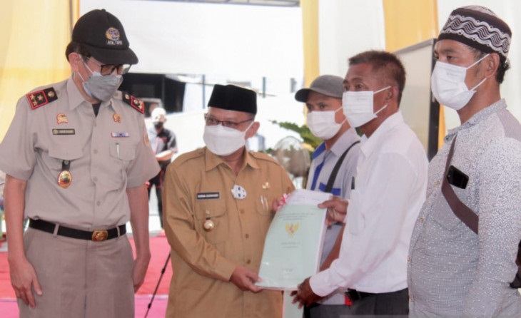 Bupati Situbondo Karna Suswandi saat memberikan sertifikat tanah kepada nelayan secara simbolis