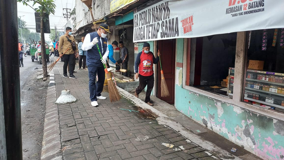Cak Hud dan Wakil Ketua Tanfidziyah MWC NU Gedangan, KH. Ahmad Bashori ikut membantu menyapu kotoran sampah plastik maupun daun yang berserakan di trotoar. SP/ Sugeng Purnomo