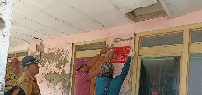 Petugas Dinsos saat Menempelkan labelisasi penerima bansos. 