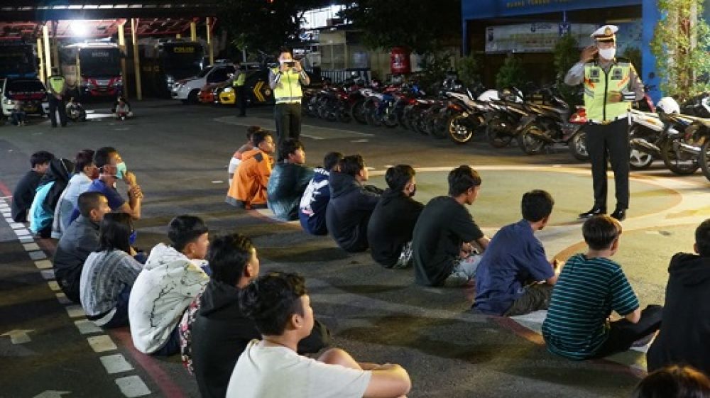 Petugas memberikan arahan kepada para pemuda yang tengah melakukan balap liar. SP/Les