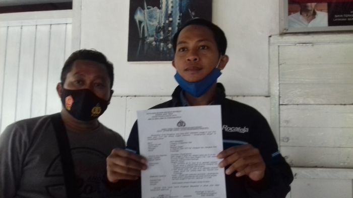 Deky Hindarko menunjukkan laporan kepolisian kepada wartawan. 