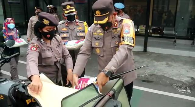 Secara simbolis Kapolres Blitar Kota masukan beras ke bagasi motor. SP/Hadi Lestariono