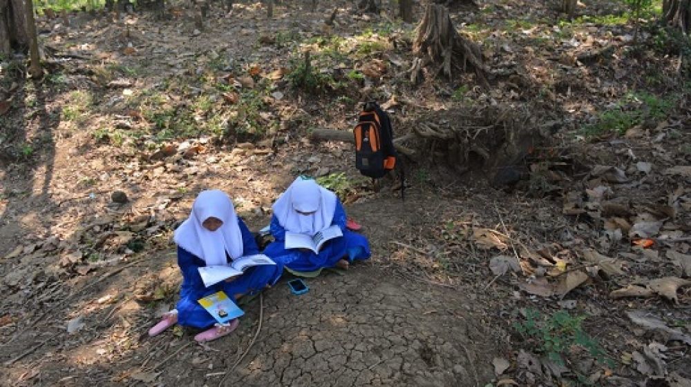 Anak-anak di Dusun Ngapus, Desa Sumberaji, Kecamatan Kabuh, Jombang saat belajar di area makam. (SP/M. Yusuf) 