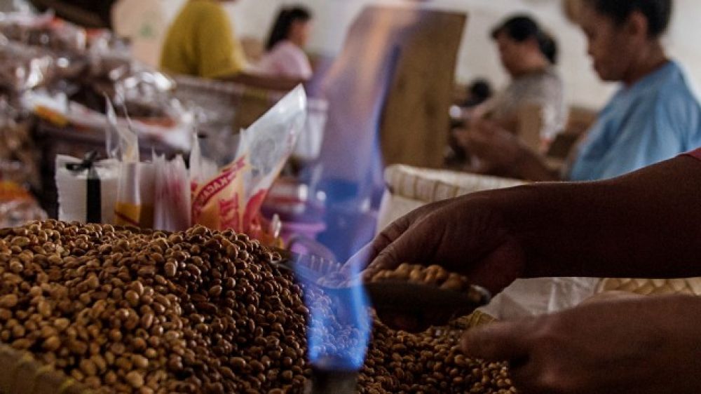 Pekerja menggunakan gas alam saat membungkus oleh-oleh makanan ringan di pusat pengolahan makanan ringan.  SP/Foto: Antara