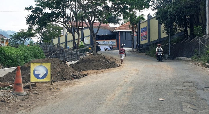 Pengerjaan pelebaran jalan untuk memperlancar akses utama ke pusat wisata Pacet, Kabupaten Mojokerto
