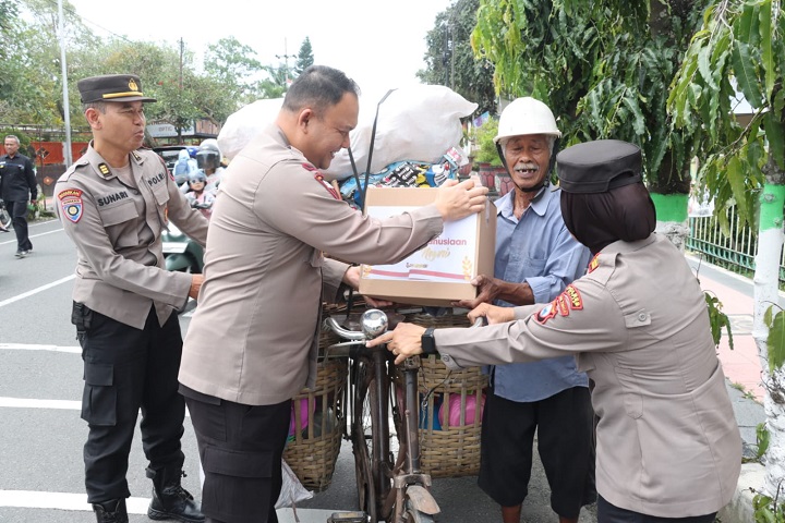 AKBP Anhar Kapolres Blitar didampingi Kasat Binmas lakukan pembagian bansos pada warga. SP/Lestariono