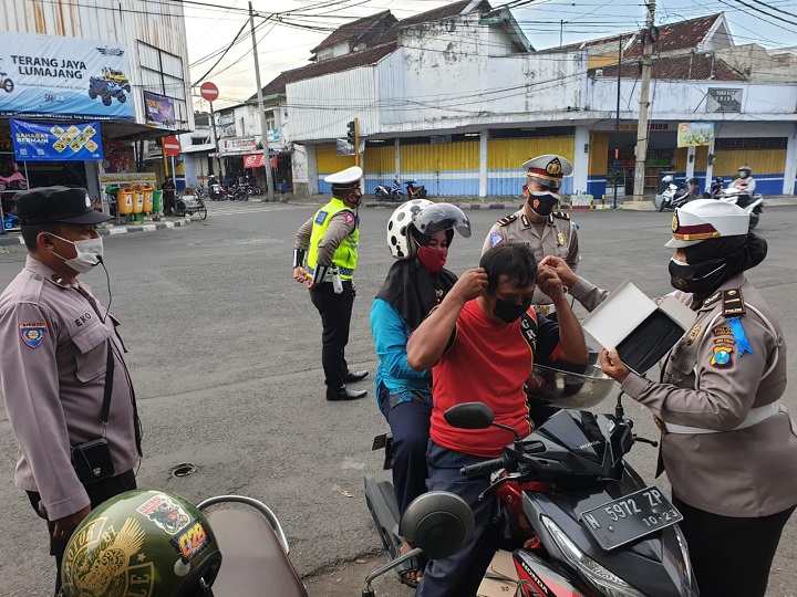 Petugas membagikan masker kepada pengendara motor. SP/Lim
