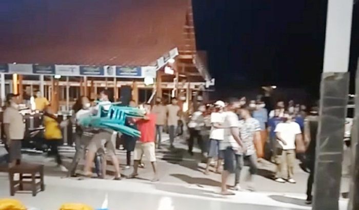 Ibu-ibu hendak melempar kursi pengunjung kepada petugas, beruntung bisa dihalang-halangi warga. 