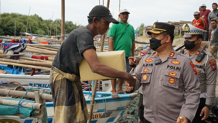 Kapolres AKBP Mochamad Nur Azis didampingi Kasatlantas AKP Agung Fitransyah membagikan paket sembako kepada nelayan. SP/Grs