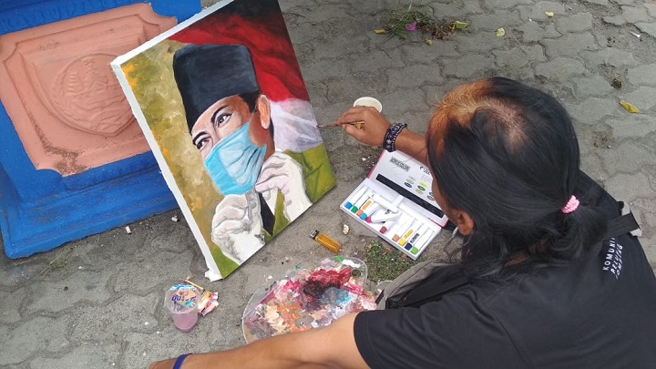 Pelukis saat melukis dengan tema Hari Pahlawan 10 November di Alun-Alun Jombang. SP/M Yusuf