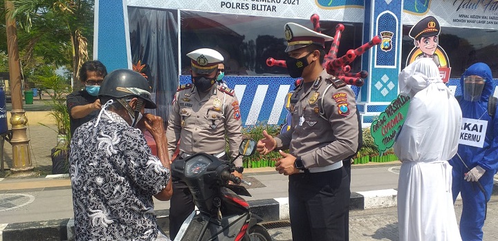Petugas saat menghentikan seorang pengendara yang tak menggunakan masker, dalam peristiwa tersebut nampak pula pocong sebagai simbol kematian akibat covid-19. SP/Hadi Lestariono