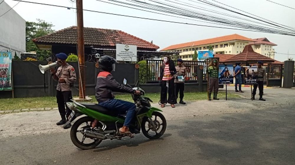 Anggota Brimob Kompi II Detasmen A, Tandes, Surabaya mensosialisasi warga dan pengendara yang melintas untuk mematuhi protokol Kesehatan. SP/tyan