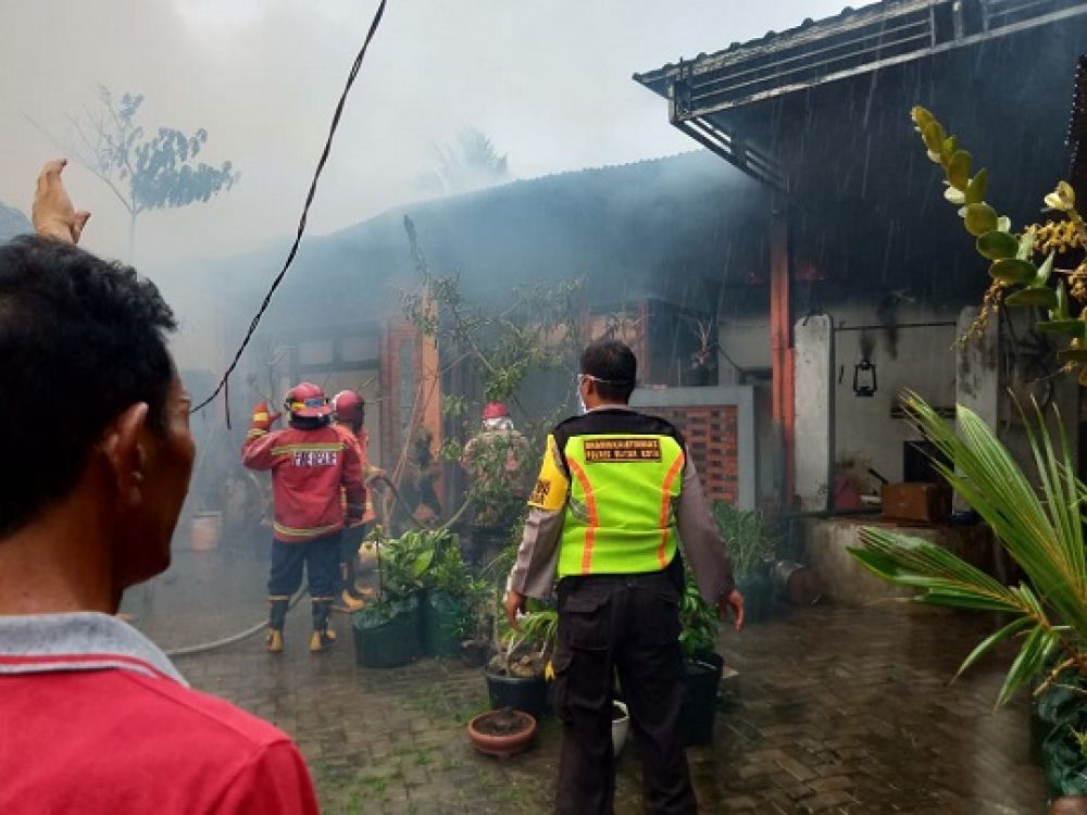 Petugas saat memadamkan api dari Gudang produk kerajinan bathok kelapa. SP/Les