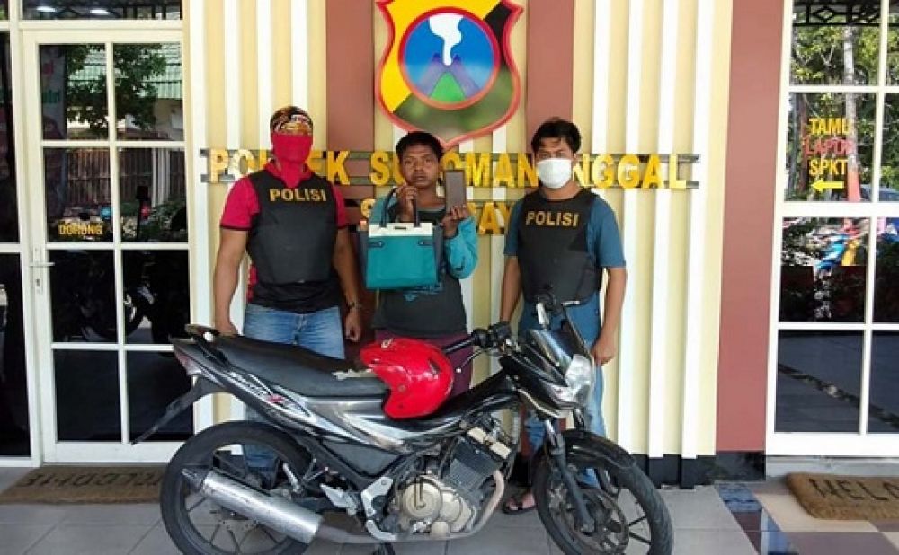 Pelaku (tengah) saat diamankan di Mapolsek Sukomanunggal Surabaya. 