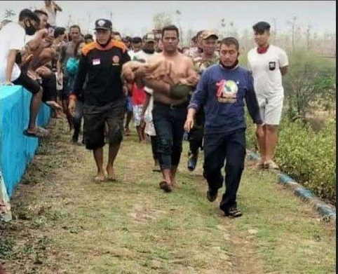 Warga menggotong jenazah korban yang baru saja dievakuasi dari dalam Waduk Dawuhan.