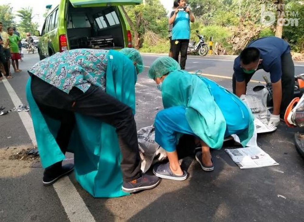 Petugas mengevakuasi jenazah korban laka lantas. 