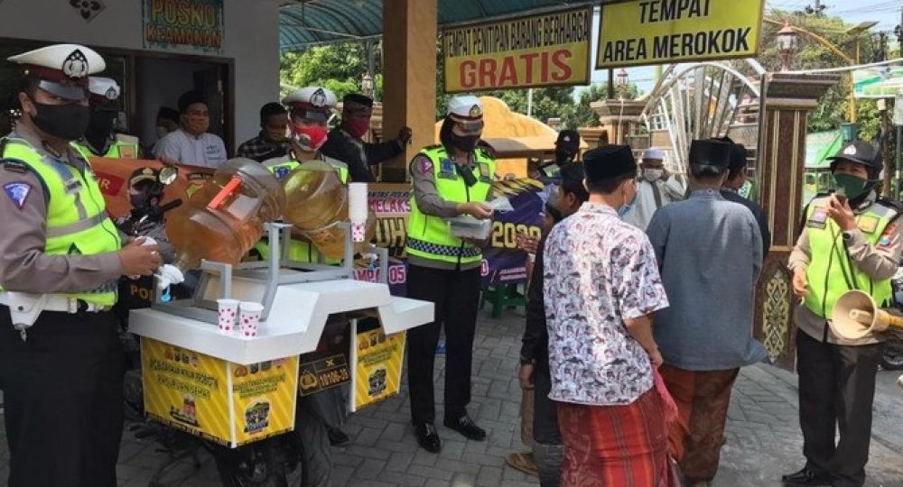 Anggota dari Polres Pasuruan membagikan minuman probiotik secara gratis kepada warga dengan tujuan untuk meningkatkan daya tahan tubuh serta menekan penyebaran covid-19. 