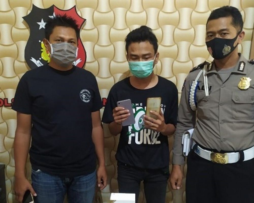 Agus Rivaldo menunjukkan barang bukti handphone milik korban yang dicurinya.