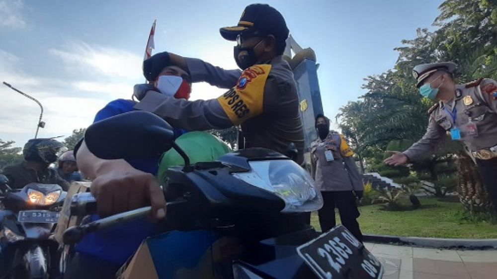 Petugas memberikan masker kepada para pengendara roda dua yang melintas. SP/tyan
