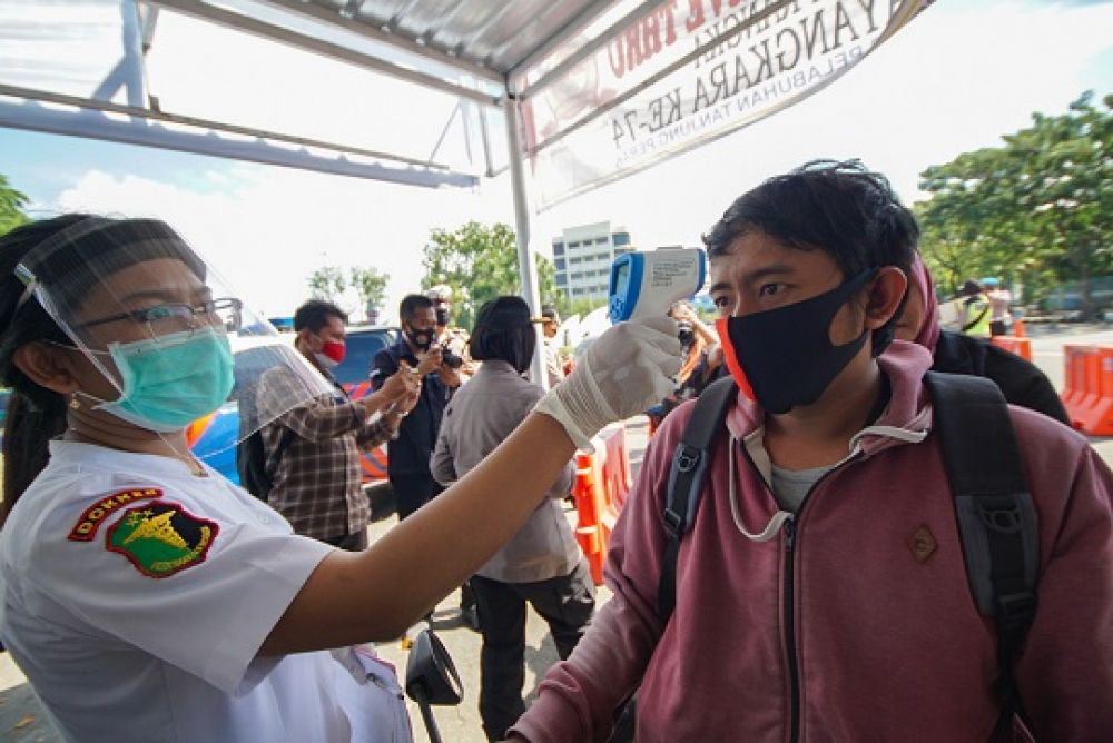 Petugas mengukur suhu tubuh para pengendara sebelum melakukan rapid test. SP/julian