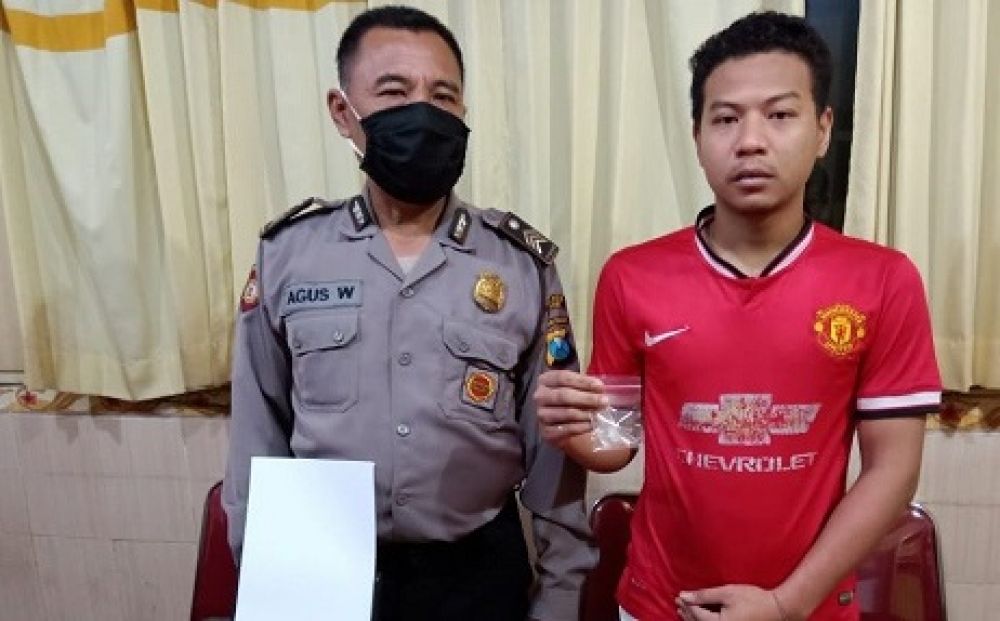 Dimas Riki Purbowo menunjukkan sabu paket hemat saat diamankan di mapolsek Menganti. 