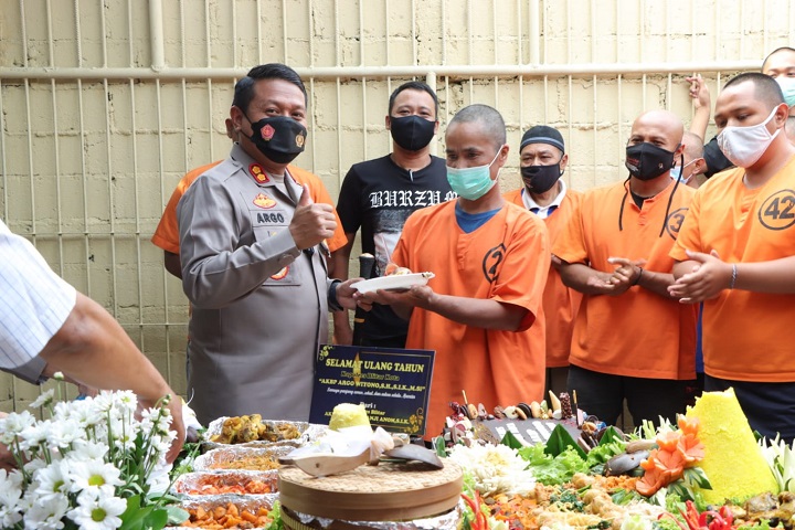 Kapolres Blitar Kota AKBP Argowiyono memberikan potongan nasi tumpeng kepada salah satu tahanan. SP/Hadi Lestariono