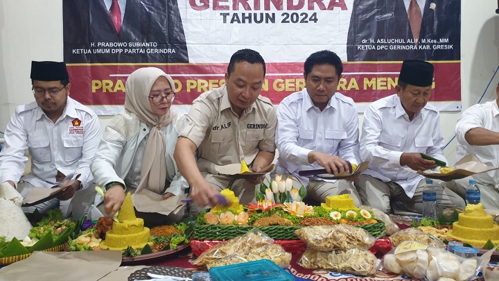 Ketua DPC Partai Gerindra Gresik dr Asluchul Alief memotong tumpeng menandai peresmian kantor baru partai di bekas terminal Bundaran GKB. SP/Grs