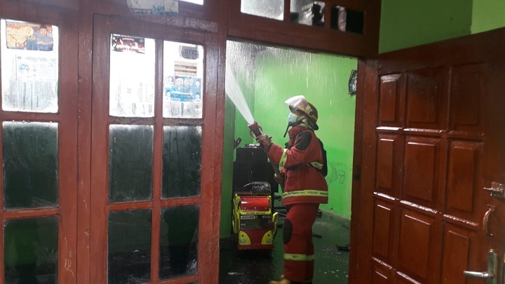 Damkar dibantu warga memadamkan api yang membakar rumah. SP/Les